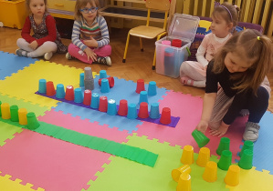 dzieci układają rytmy z kolorowych kubeczków